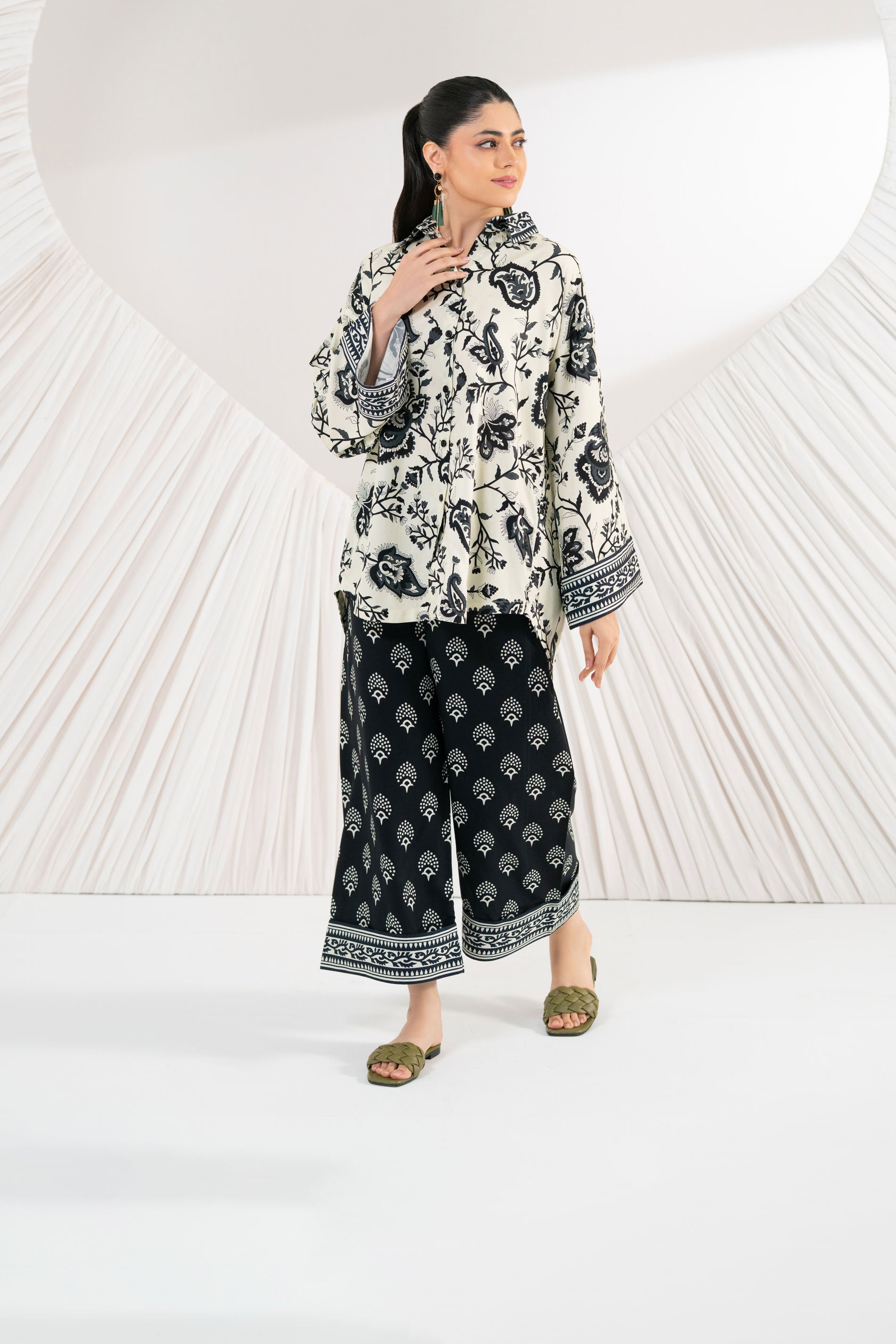 Woman wearing a black and white patterned outfit on a white background
