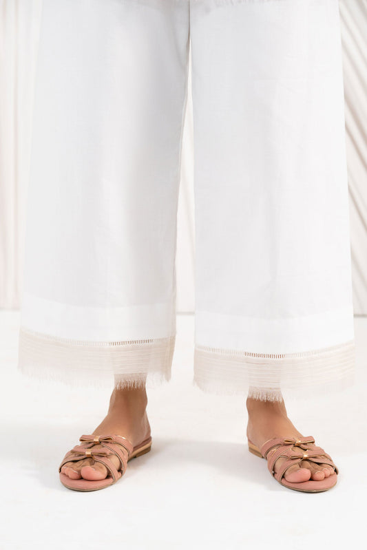 Person wearing white pants and tan sandals on a white background