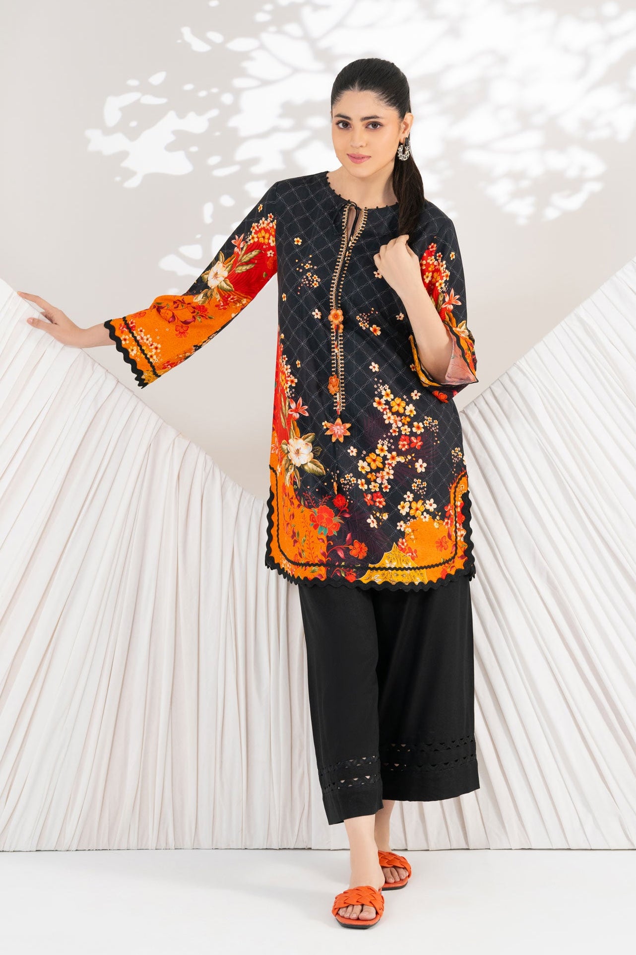 Woman in a floral dress standing in front of a heart-shaped backdrop