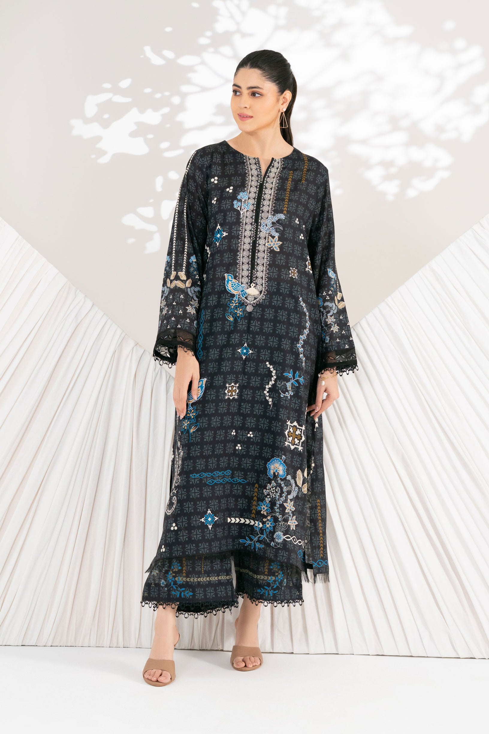 Woman wearing a black and blue patterned dress with a white background