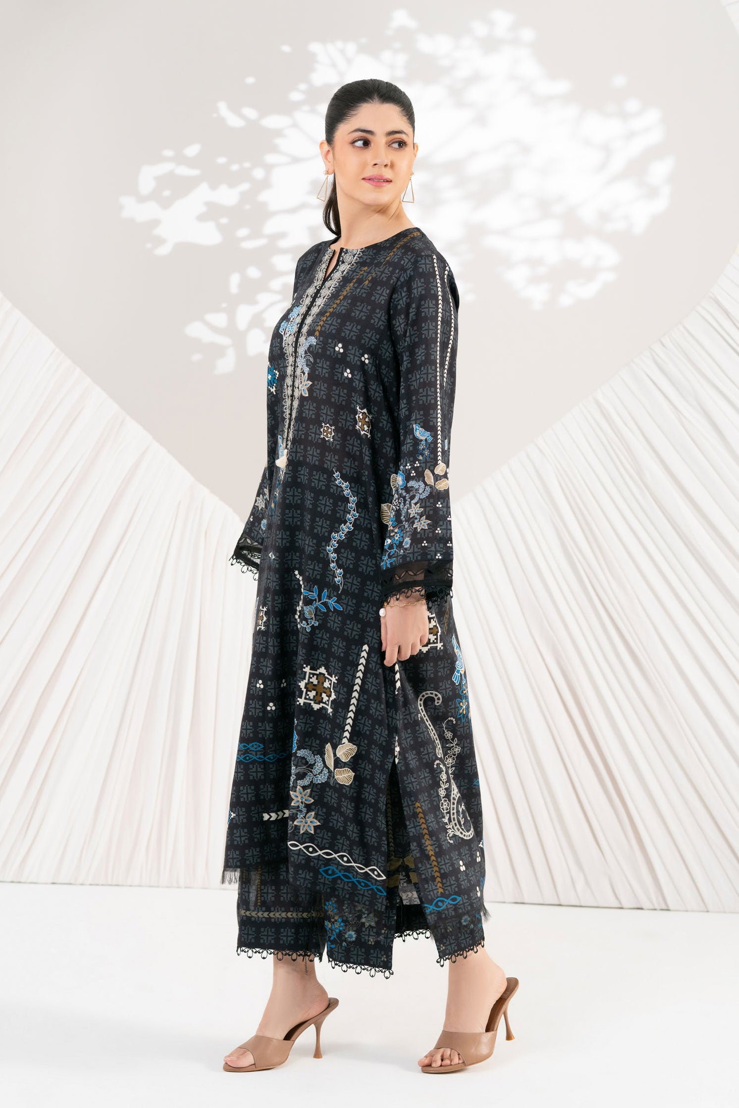 Woman wearing a dark floral dress with a white background